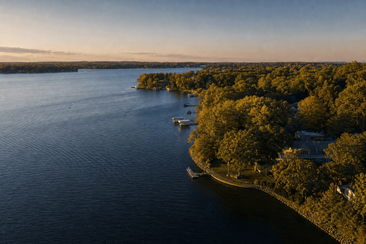 Aerial view of a wooded Lake Minnetonka shoreline and homes at golden hour